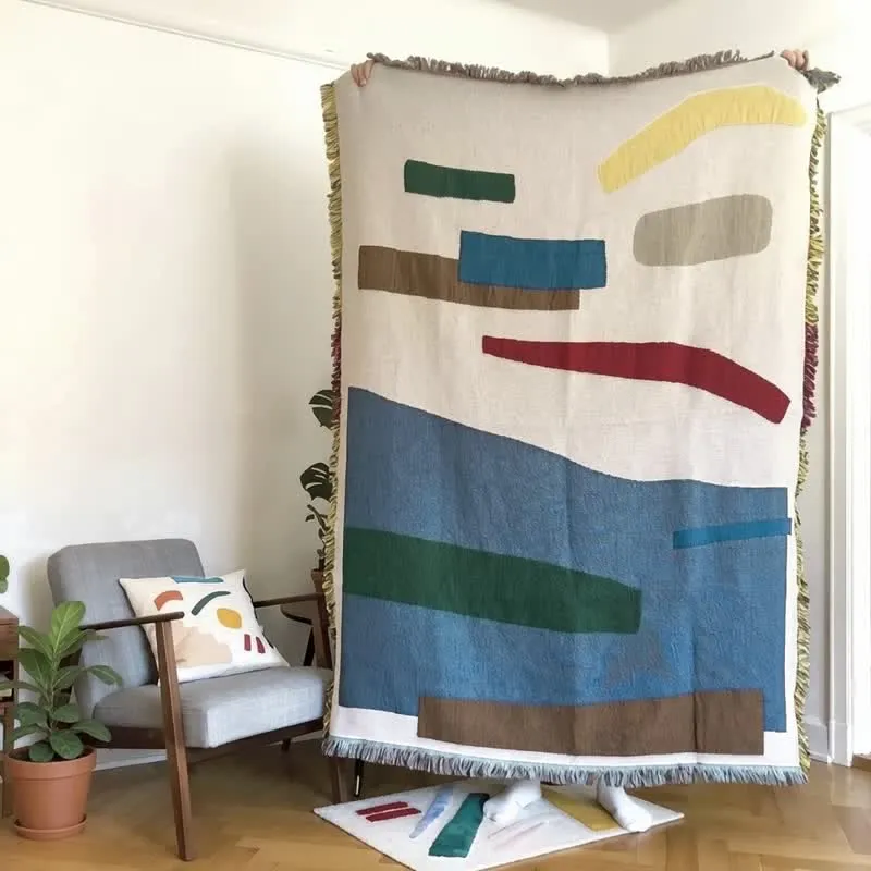 Künstlerisch gestaltete, geometrische, mit Fransen und Quasten verzierte Tagesdecke
