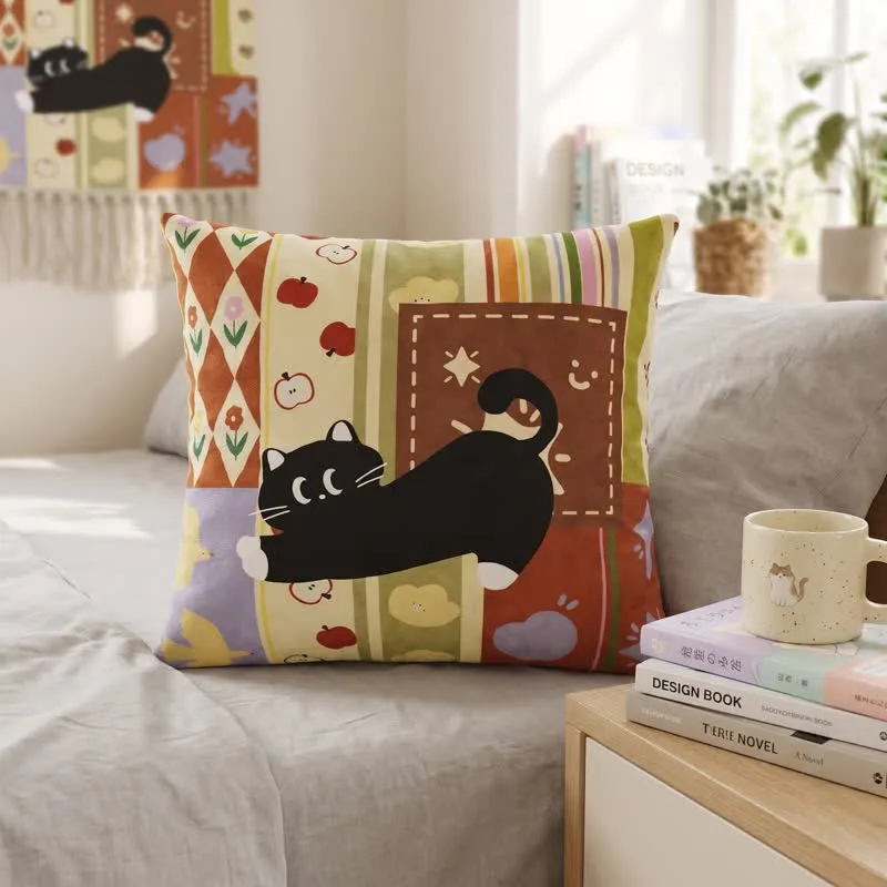 Dekoratives Kissen mit verspieltem Patchwork-Muster und schwarzer Katze