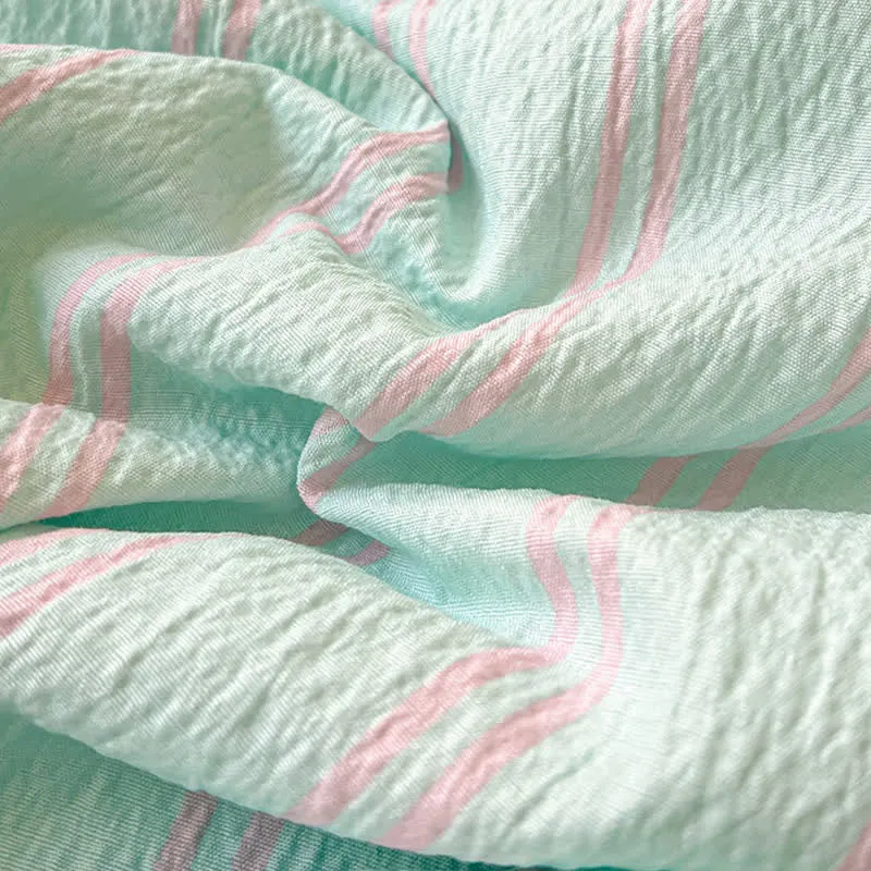 Steppdecke aus geknitterter Baumwolle mit mintfarbenen Streifen und abgesetztem Besatz