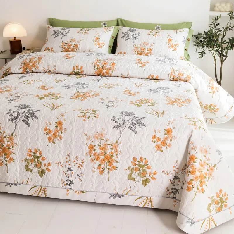 Orangefarbene Baumwollsteppdecke mit floralem Botanikdruck